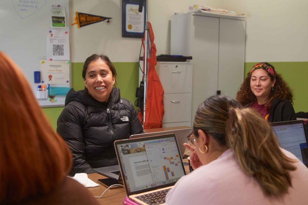 Andrea Vidaurre with her colleagues at the People’s Collective for Environmental Justice, working together on laptops around a table.