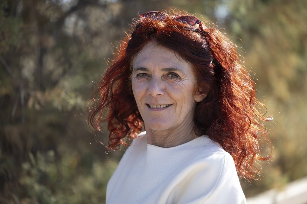 Portrait of Teresa, with red hair and a white shirt.